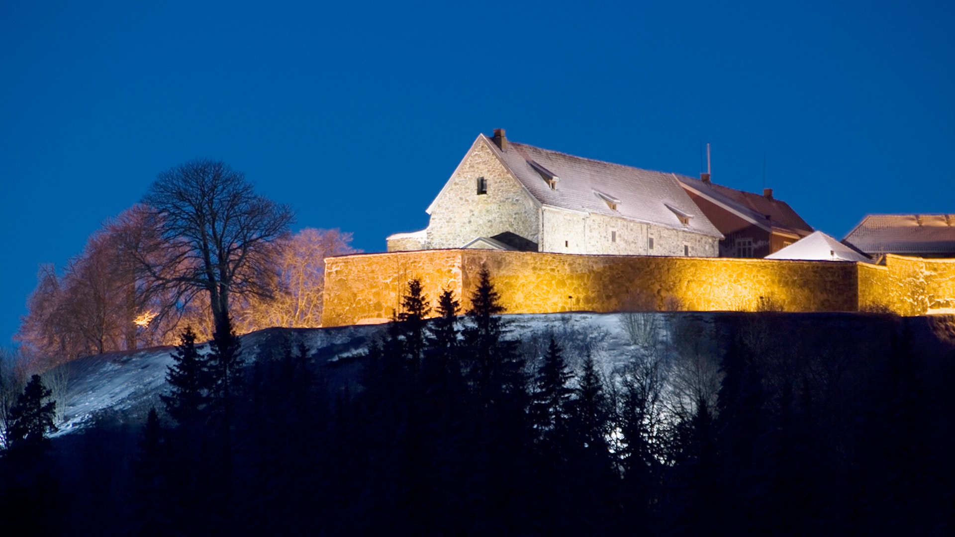 The stone buildings at fortress of Kongsvinger lit up at night.