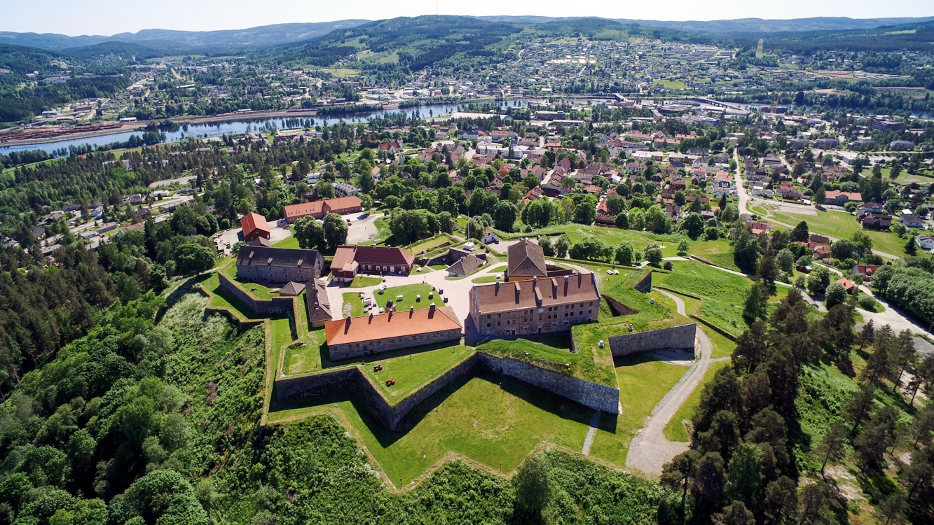 Star shaped walls of the fortress of Kongsvinger on a sunny summer day with the city of Kongsvinger and river Glomma in the distance.