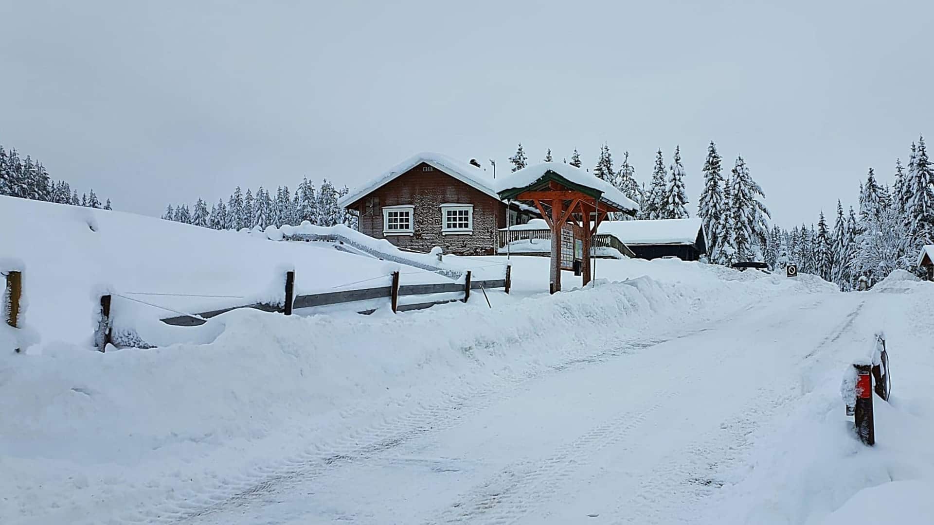 Wooden buildings of Pruterud ski resort is covered in snow and ice on a cold winter day.