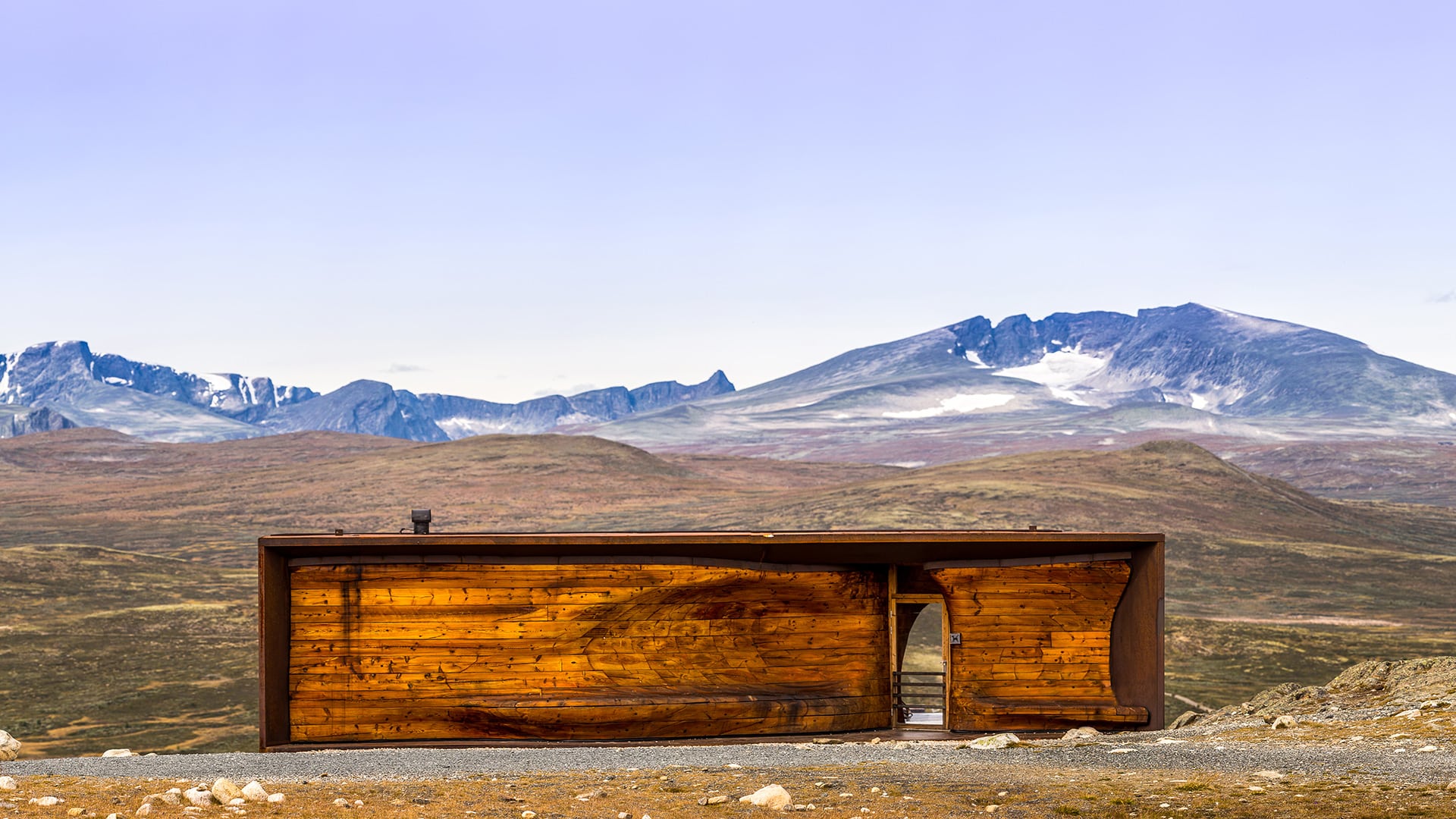 Wild Reindeer Pavilion. A wooden building in front of snow covered mountain Snøhetta on Dovrefjell.